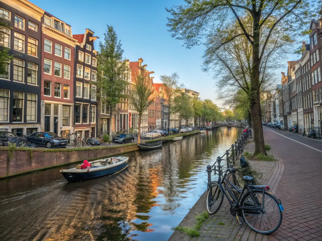 A picturesque scene of a canal in Bruges, Belgium, lined with medieval buildings and blooming flowers, with a Mass Excursion cruise ship gently gliding through the water. This image captures the historic charm and scenic beauty of the Belgian waterways.