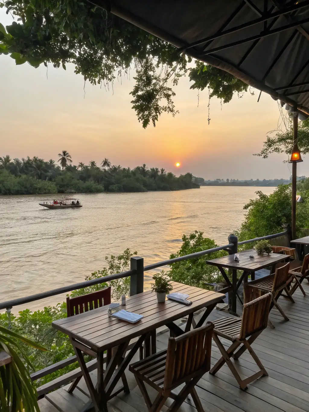 Picturesque view of the Mekong River at sunset, with traditional wooden boats sailing along the calm waters, reflecting the golden light and serene beauty of the landscape.